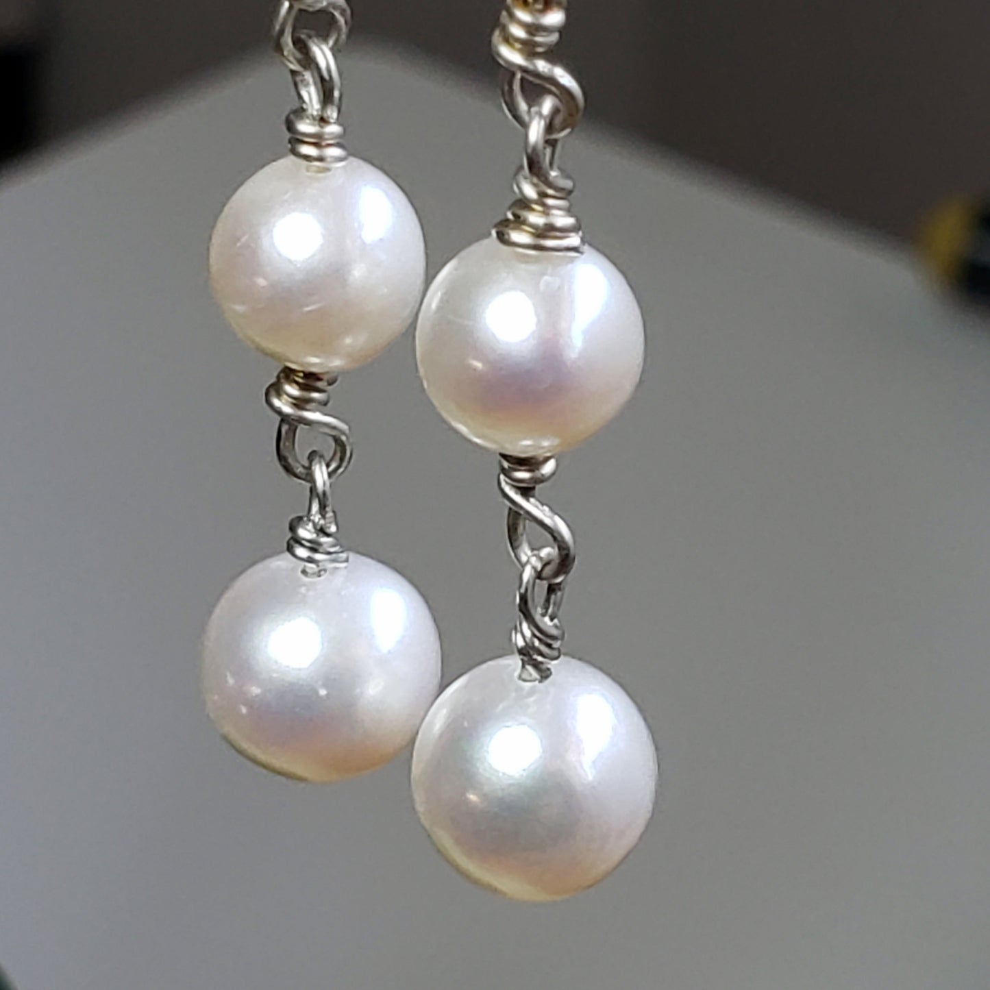 Long pearl earrings with three freshwater pearls, wrapped with sterling silver wire connectors hung from silver latch back closures.