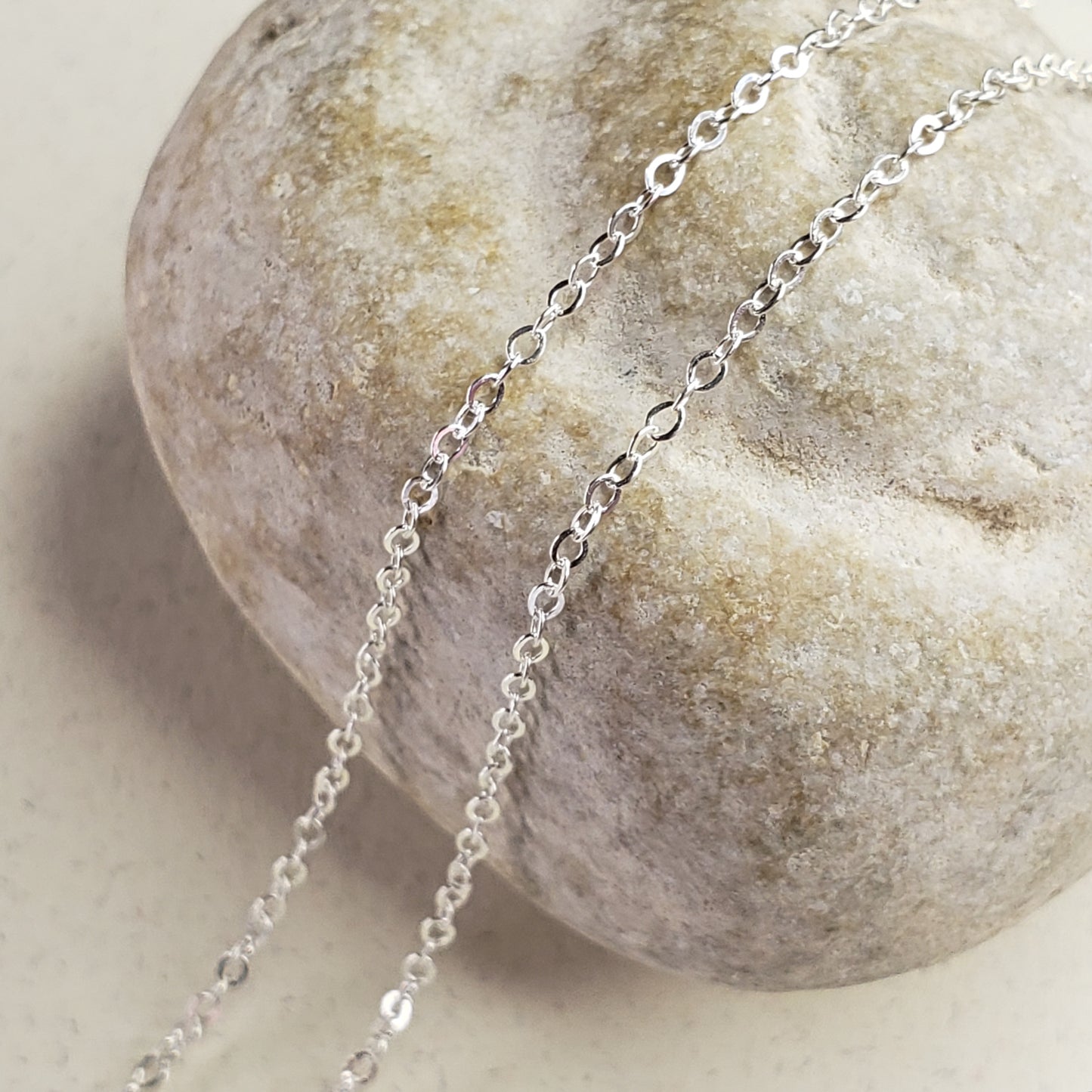 Image of delicate sterling silver chain across a fossil rock for display