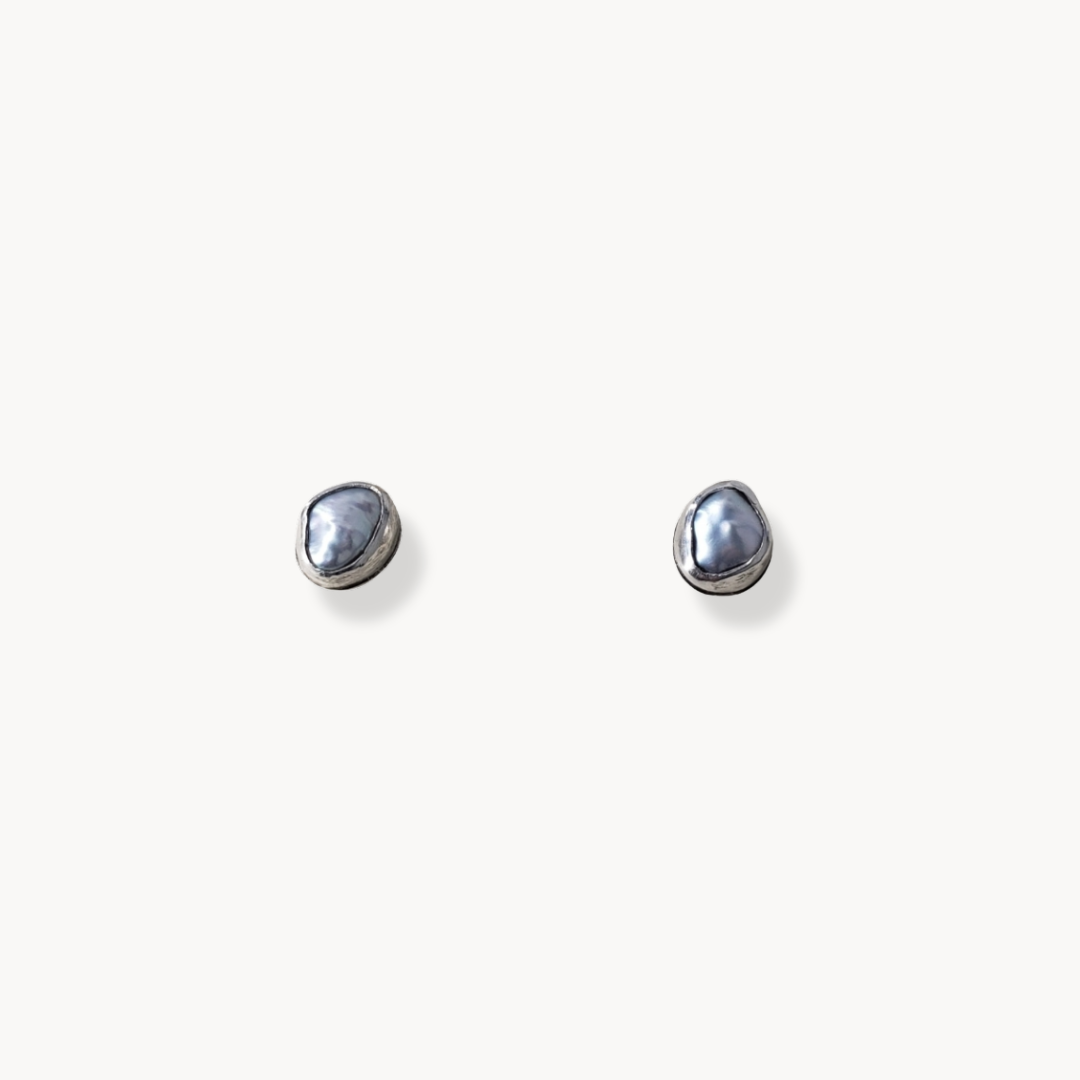 Bezel set organic pearl stud earrings against white background