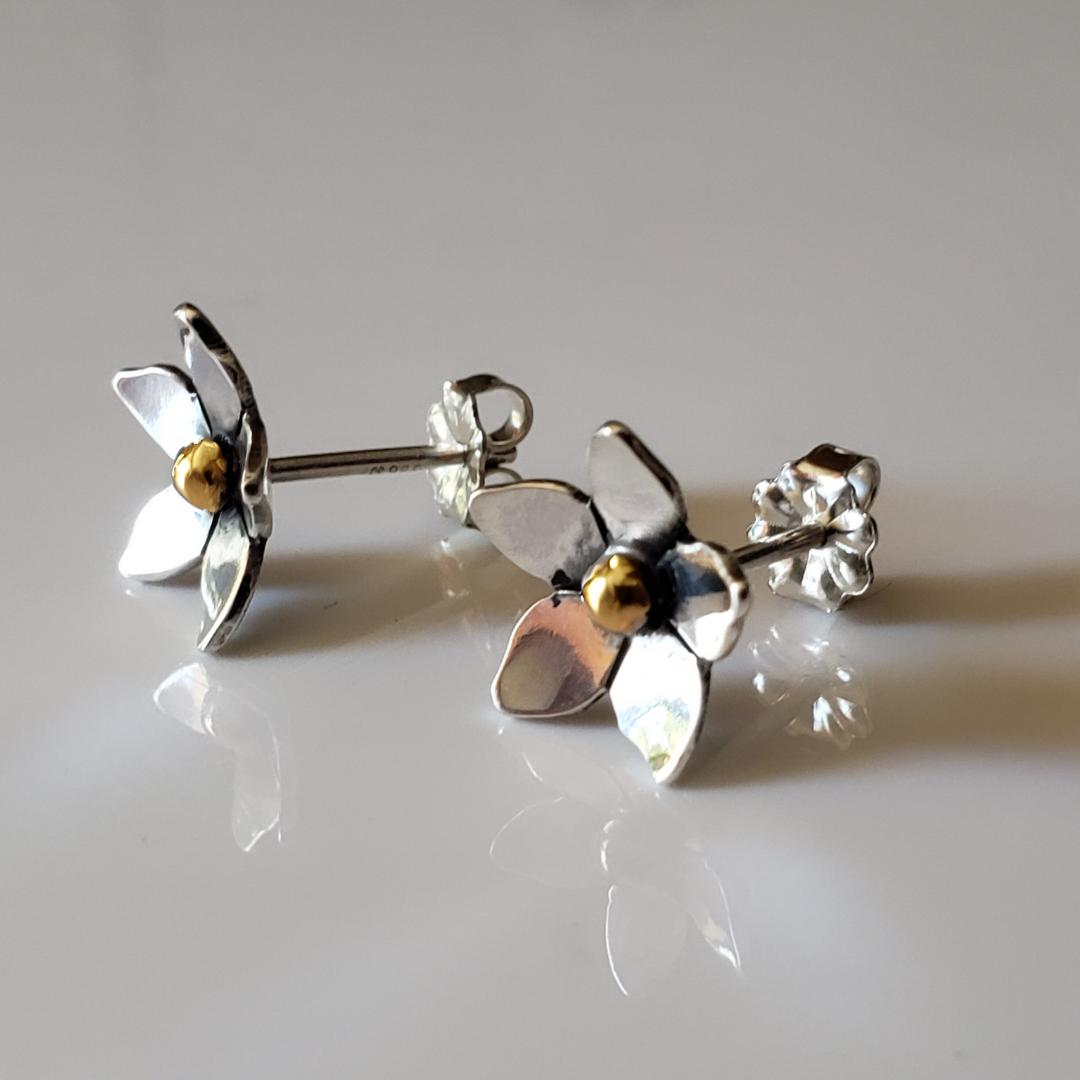 Small mixed metal sterling silver and 14k gold flower earrings against white background