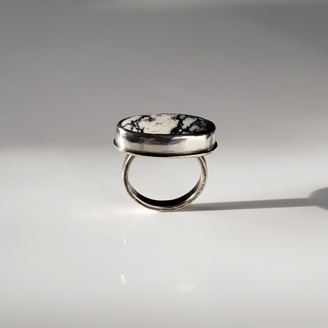 White Buffalo gemstone ring against gray background