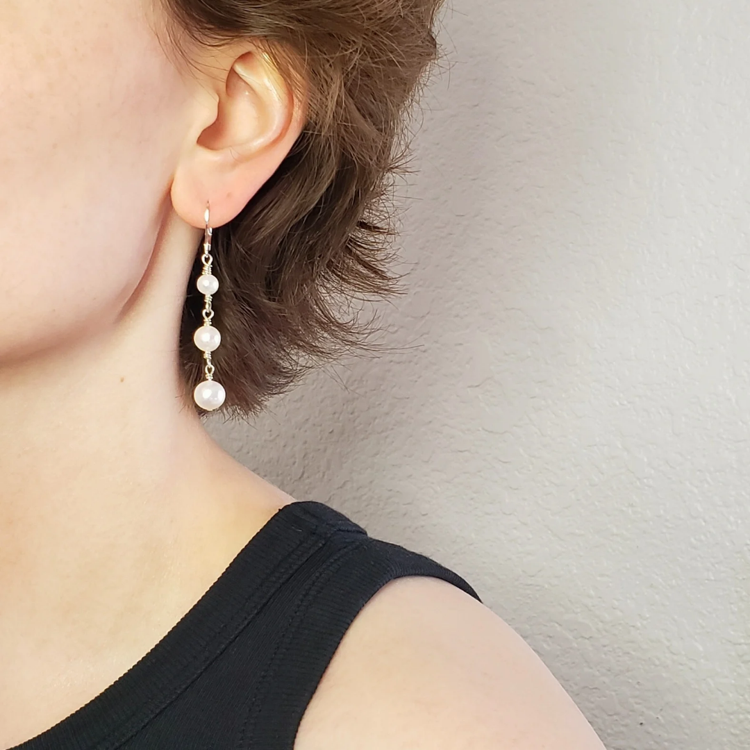 Long pearl earrings with three freshwater pearls, wrapped with sterling silver wire connectors hung from silver latch back closures.