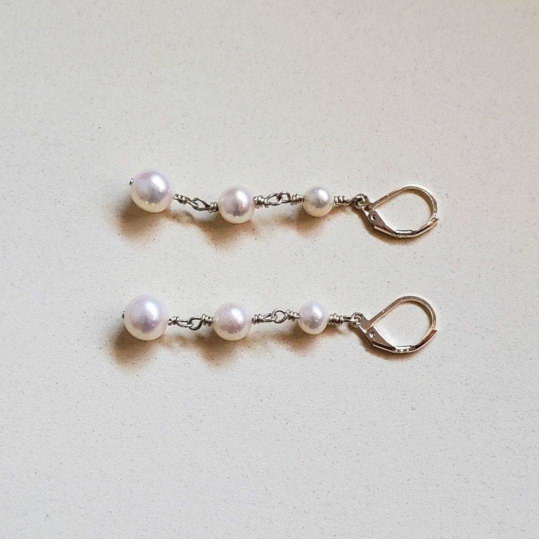 Long pearl earrings with three freshwater pearls, wrapped with sterling silver wire connectors hung from silver latch back closures.