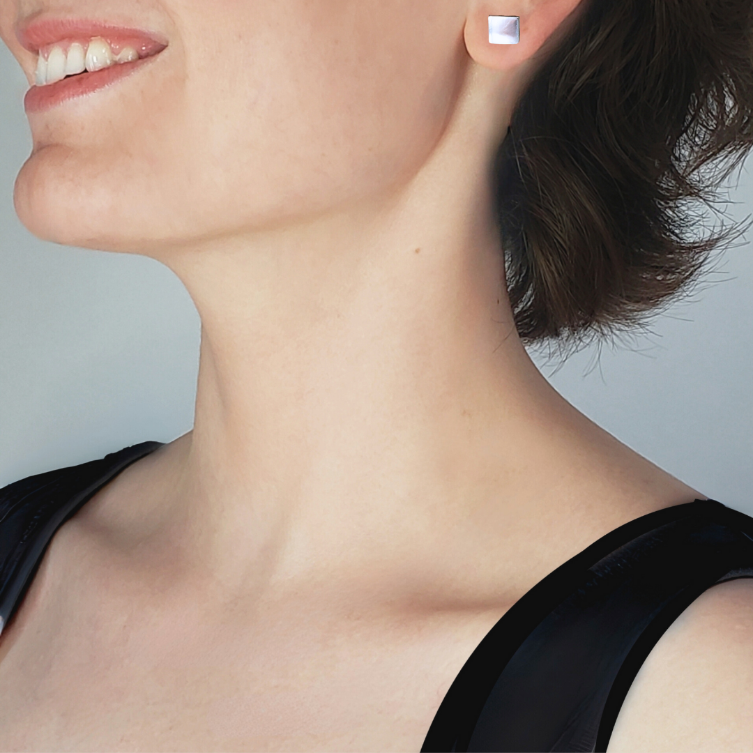 Left facing model wearing artisan crafted sterling silver square stud earrings
