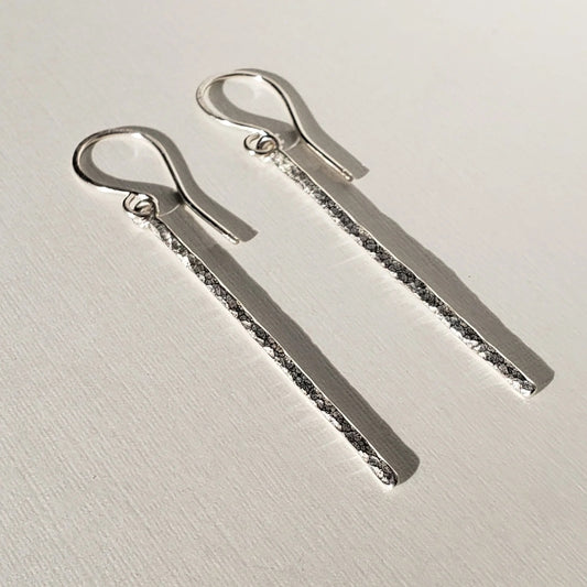 Long silver bar earrings with hammered texture hung on sterling ear wires