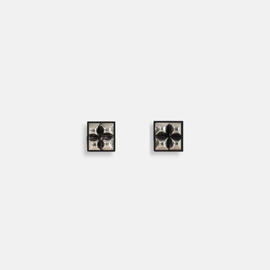 Sterling silver square stud earrings with four raised pyramid facets and post closures