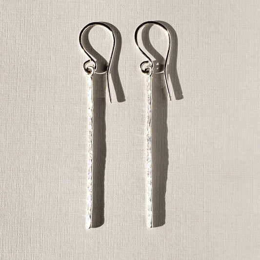 Long silver bar earrings with hammered texture hung on sterling ear wires