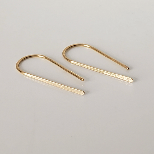 Small 14k gold threader earrings against white background 