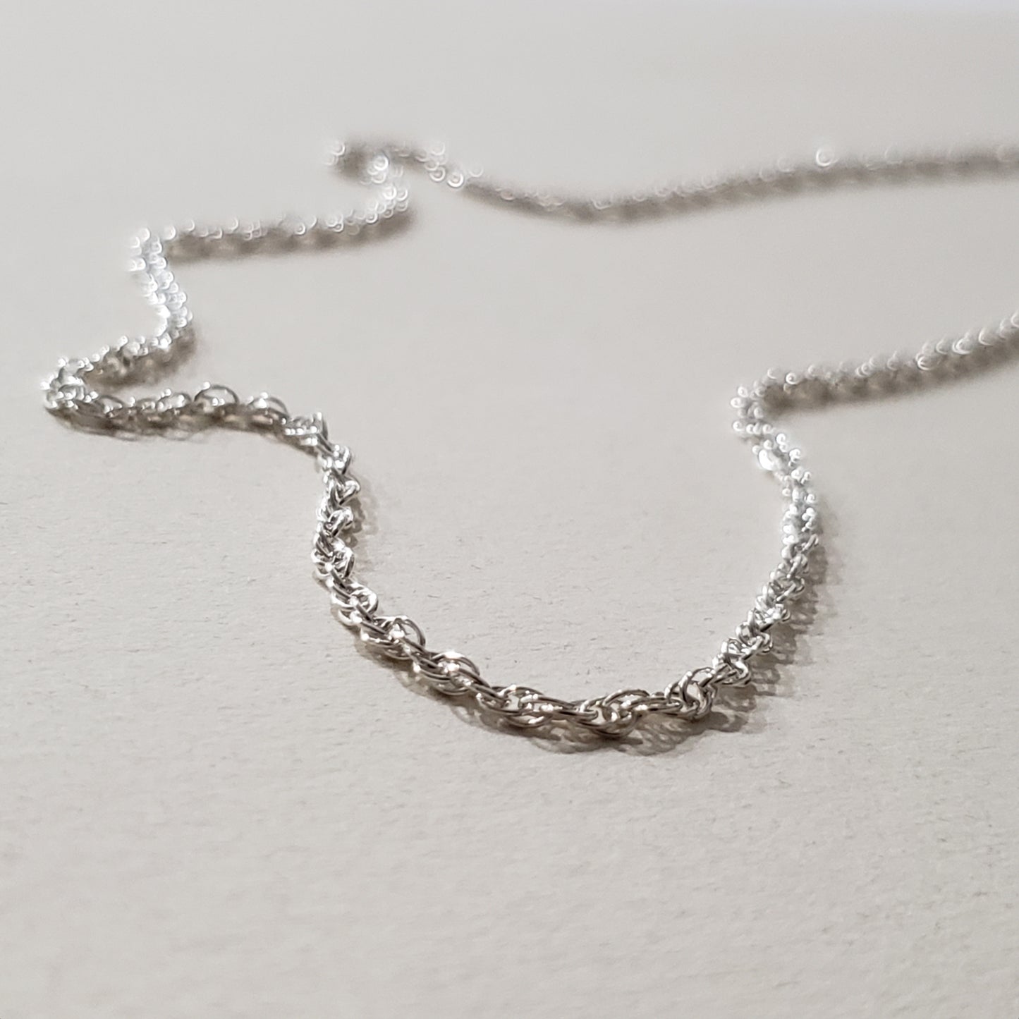 Image of an 18 inch sterling silver rope chain with lobster claw clasp closure. 