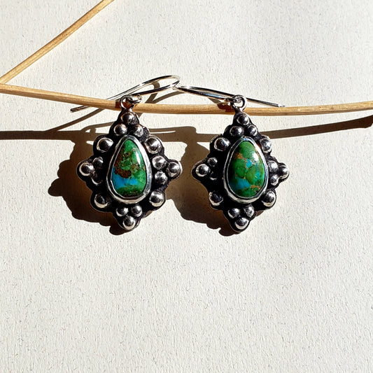 A beautiful pair of blue and green turquoise earrings surrounded by a starburst pattern of sterling silver spheres.