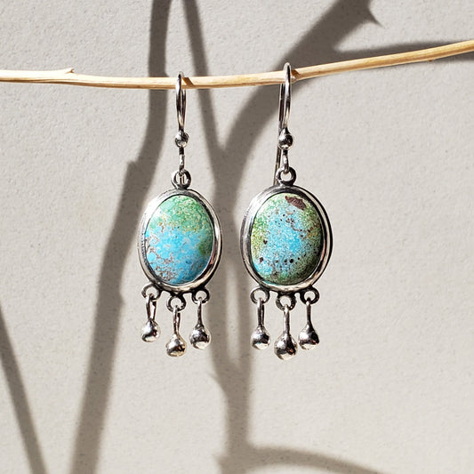 This is a beautiful pair of large oval turquoise earrings with three small round ball dangles across the bottom of the earrings. They are all handmade from sterling silver and hung from handmade sterling silver wires. These large turquoise earrings measure one and a half inches long and are half inch wide. 