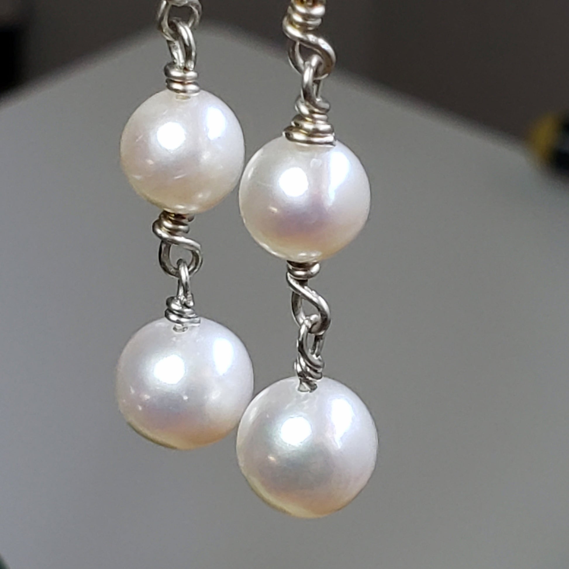 Long pearl earrings with three freshwater pearls, wrapped with sterling silver wire connectors hung from silver latch back closures.
