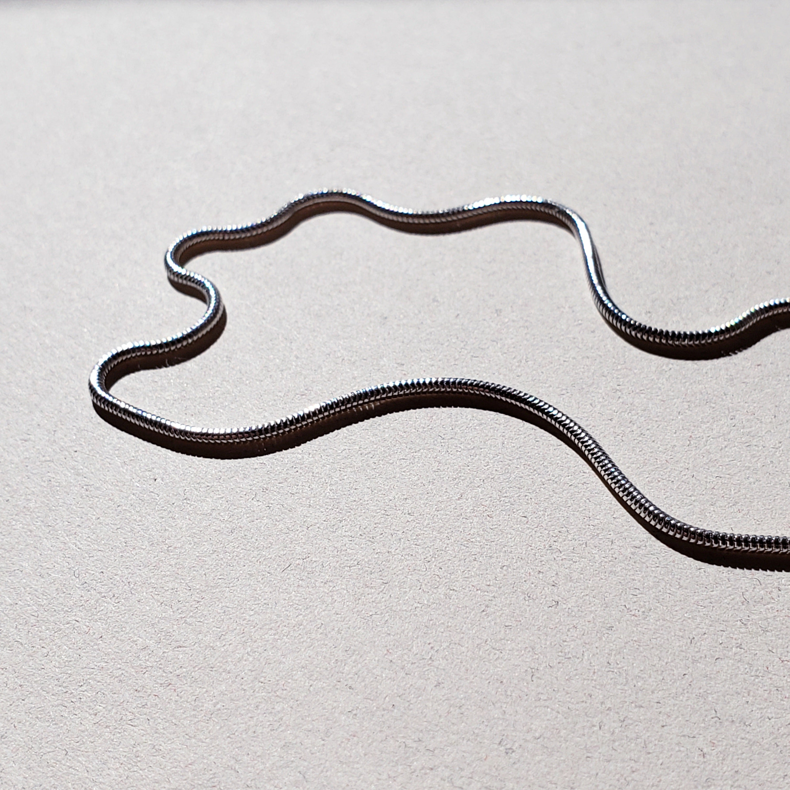 Image of sterling silver snake chain necklace on white background