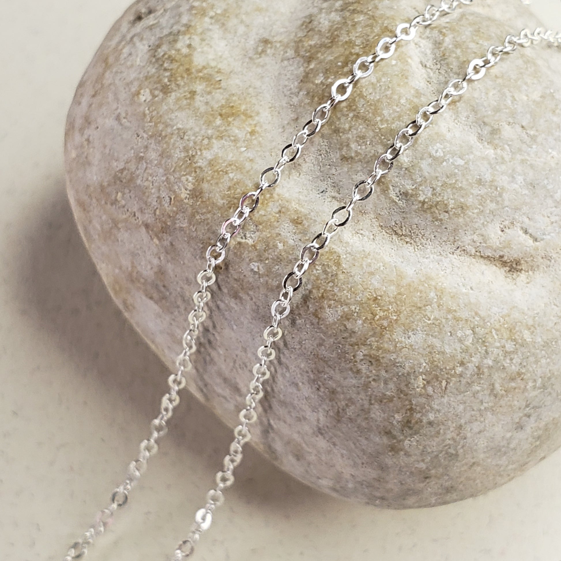 Image of delicate sterling silver chain across a fossil rock for display 