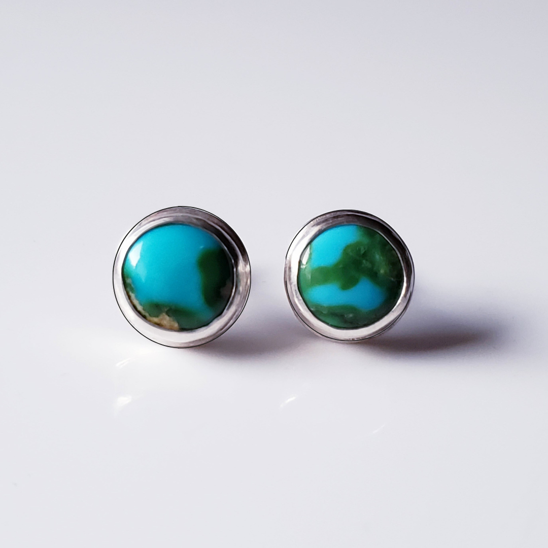 Large turquoise stud earrings against gray background 