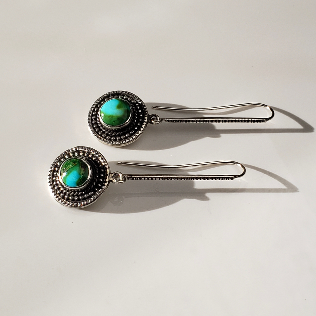 Long turquoise threader earrings against white background 