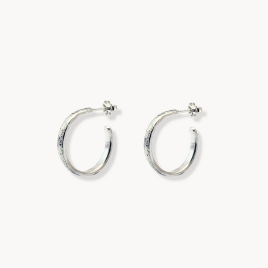 Medium silver hoop earrings with hammered finish against white background 