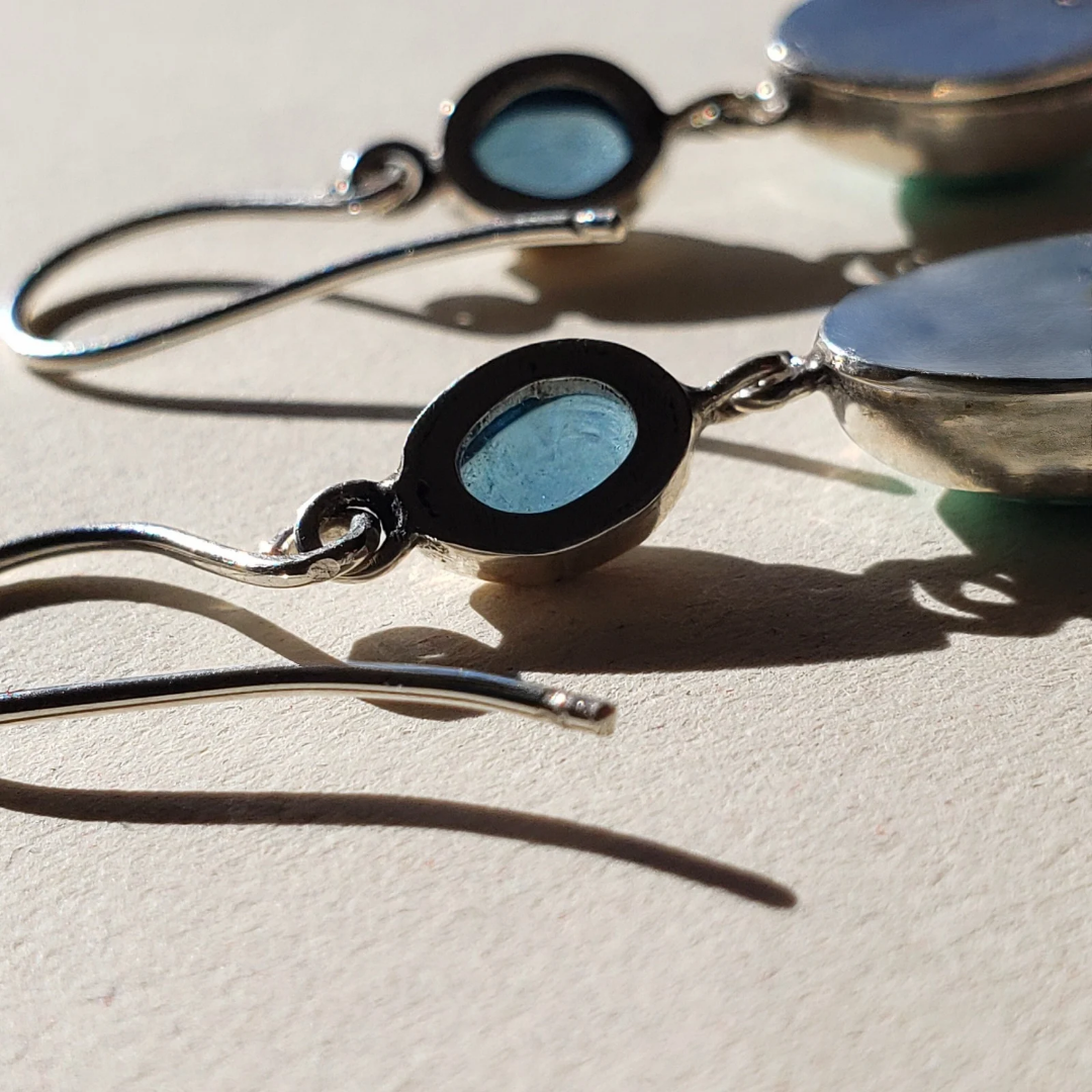 A right facing image of the backside of turquoise and silver artisan earrings