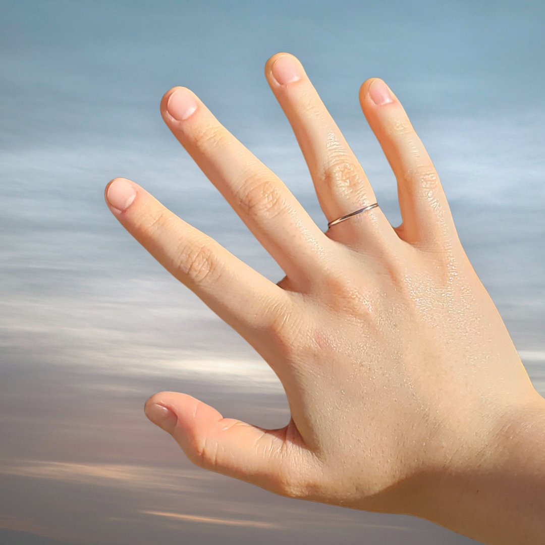 Image of a Image of dainty sterling silver ring against on a woman's right hand