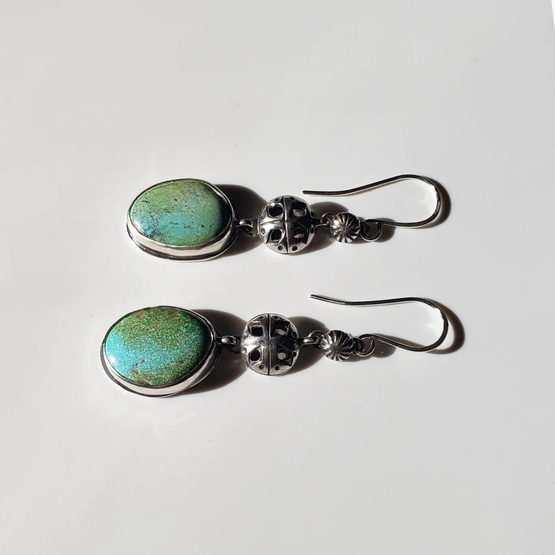 Turquoise and silver earrings against white background 