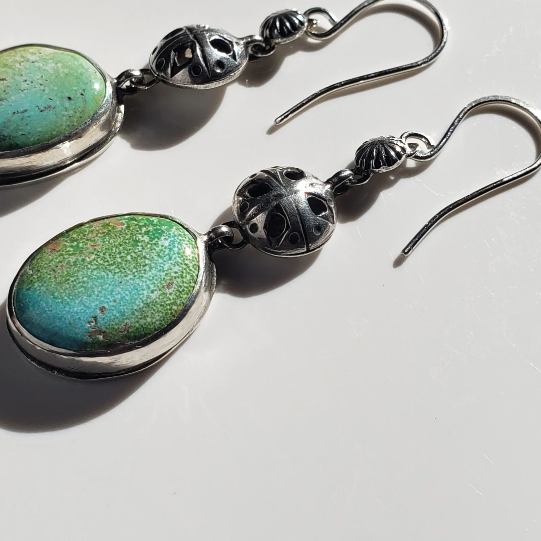 Turquoise and silver earrings against white background