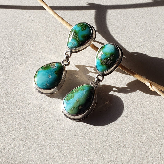 Gorgeous Sonoran turquoise drop earrings. These blue and green turquoise earrings have two stones per earrings the top stone is a reverse tear trophy stone and the bottom stone is a tear drop. These earrings are finished in sterling and fine silvers and have post closures. 