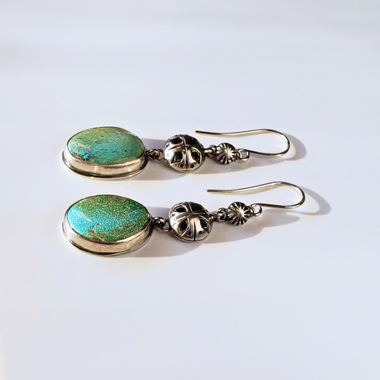 Handmade turquoise earrings against white background 