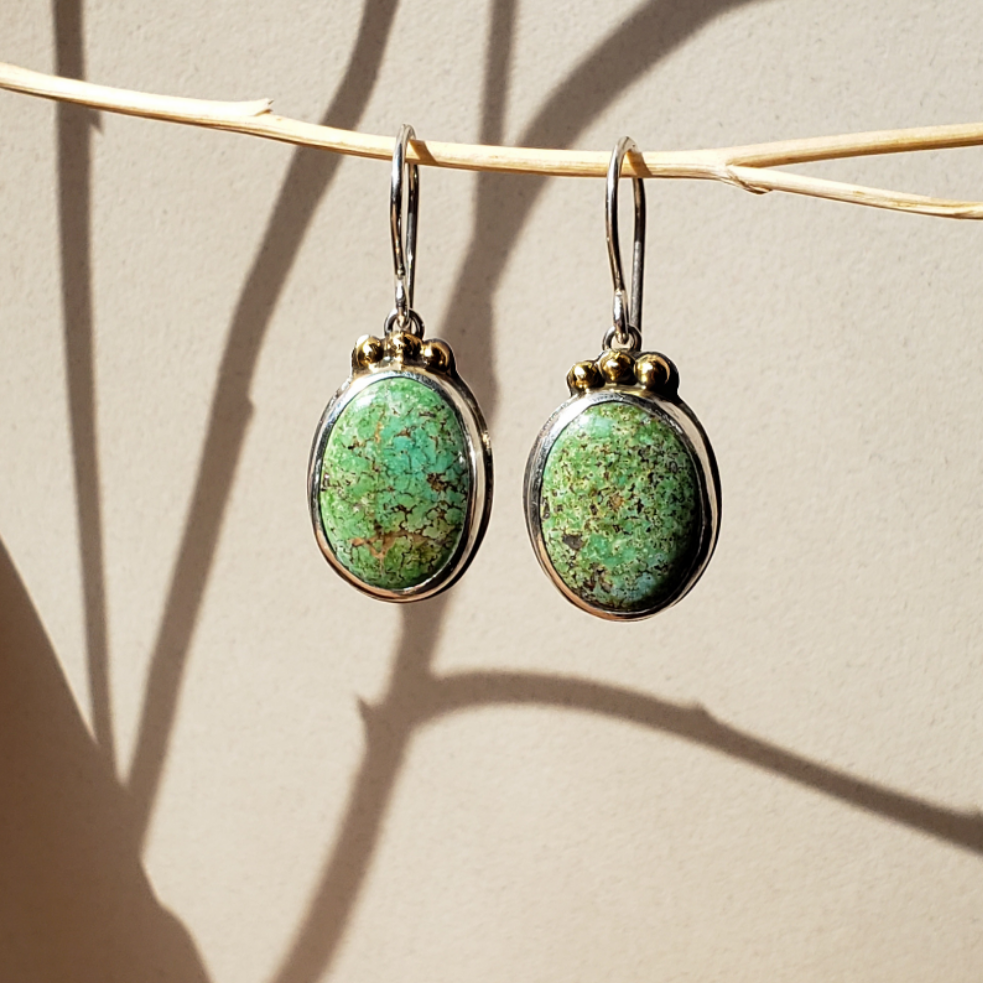 Beautiful Green oval turquoise earrings finished in sterling silver with 14k gold accents. These medium turquoise earrings are hung on sterling wires. A perfect pair of turquoise drop earrings for your quiet luxury style. 