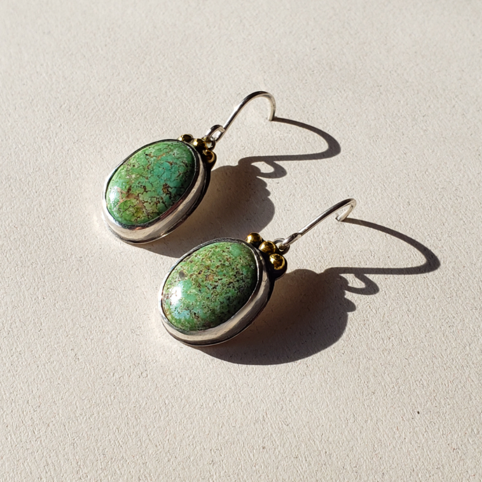 Beautiful Green oval turquoise earrings finished in sterling silver with 14k gold sperical accents. These medium sized turquoise earrings are hung on sterling wires. A perfect pair of turquoise drop earrings for your quiet luxury style. 