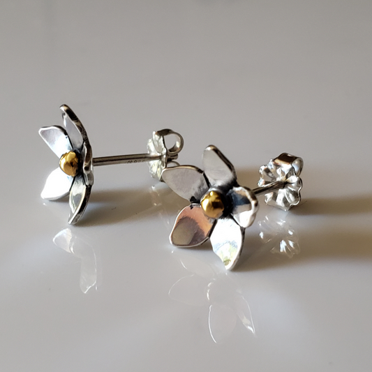 Small mixed metal sterling silver and 14k gold flower earrings against white background 