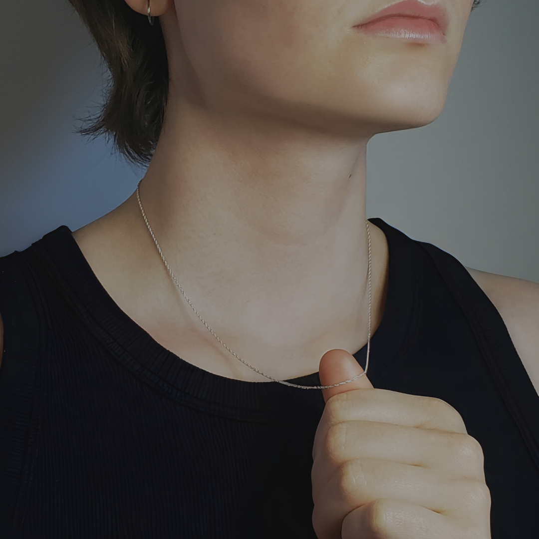 Left facing model profile wearing sterling silver chain necklace