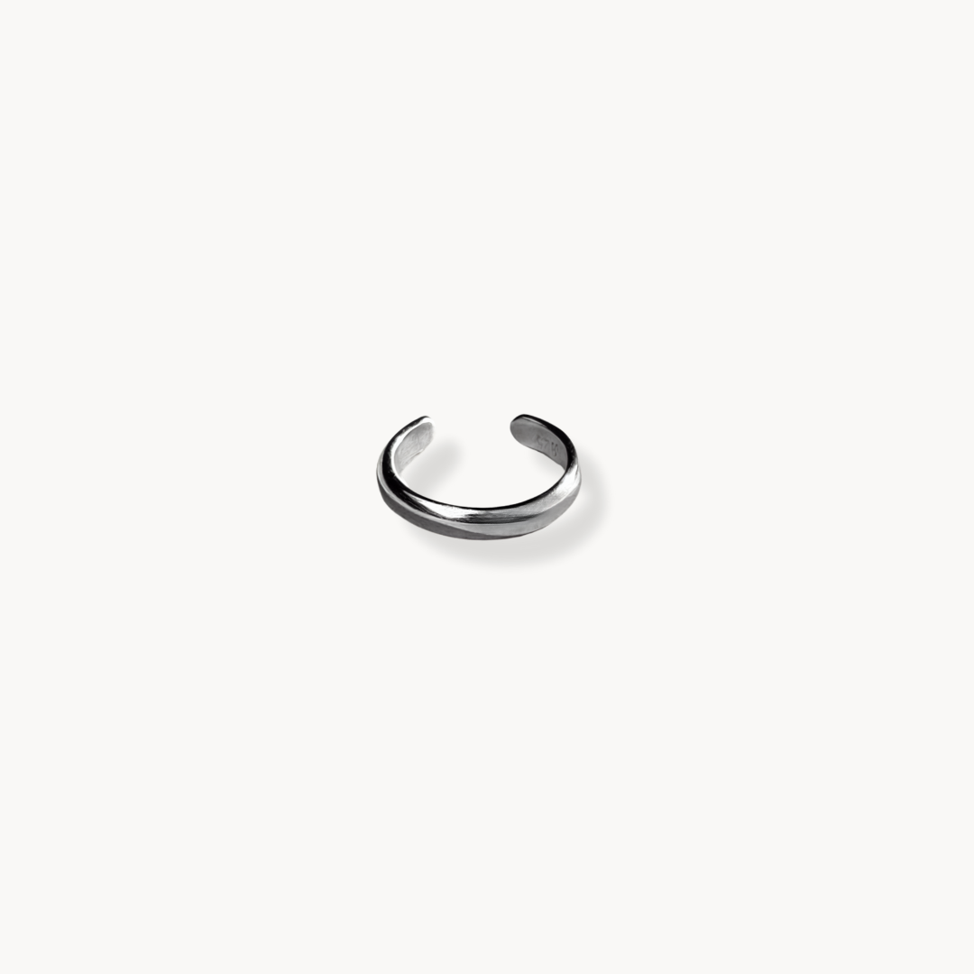 A plain silver ear cuff ring against a white background 