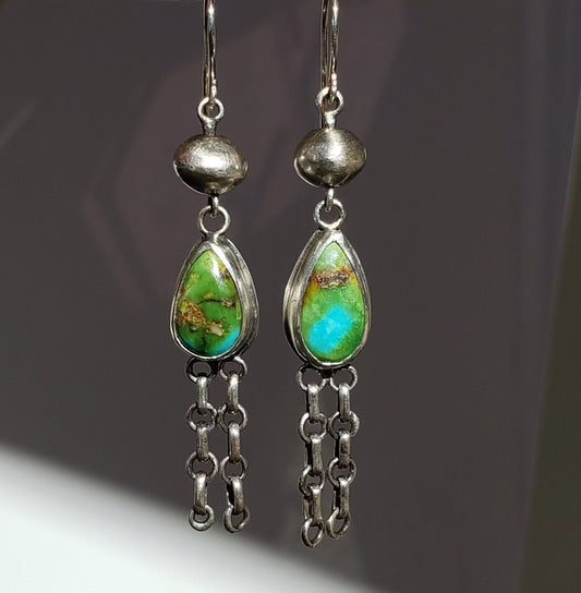 Long blue green turquoise dangle earrings against white background