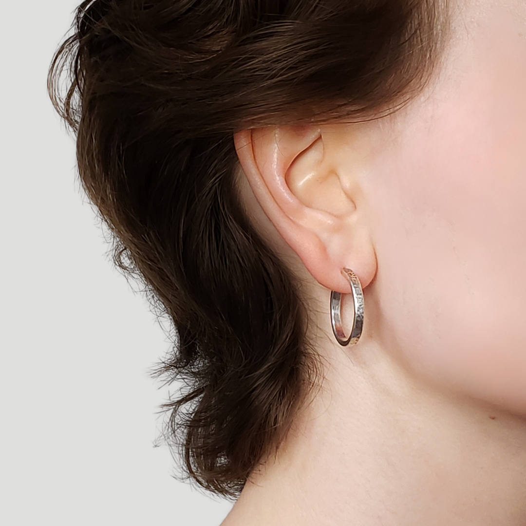 Right facing model wearing silver hoop earrings 