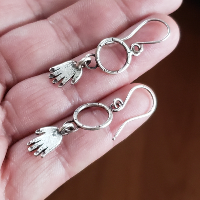 Silver hands on hoop earrings