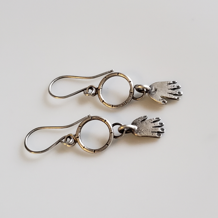 Silver hands on hoop earrings