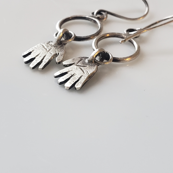 Silver hands on hoop earrings