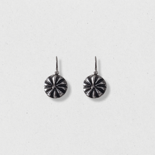 Small silver concho earrings on white background 