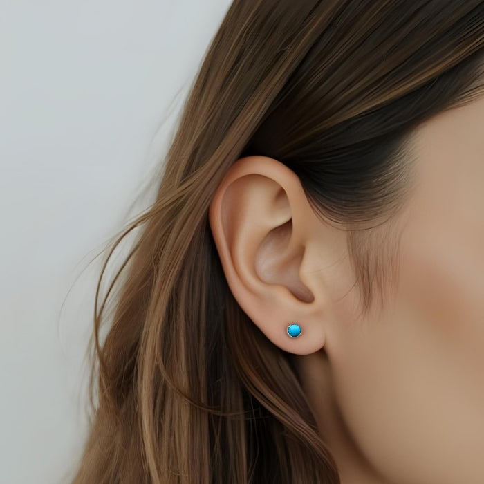 Woman wearing small round turquoise stud earring