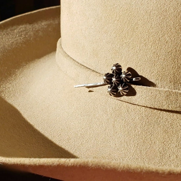 Image of left facing stetson cowboy hat with sterling silver hat jewelry on the hat band 