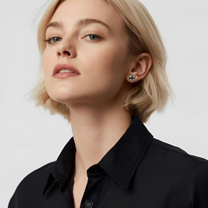 Blonde woman with short hair wearing a pair of sterling silver square stud earrings with four raised pyramid facets and post closures