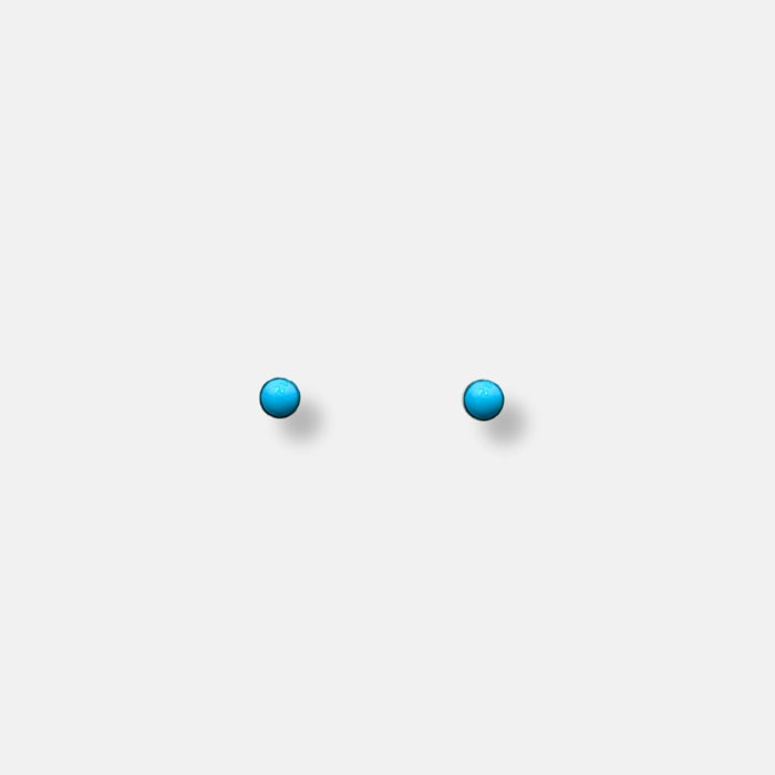 Small turquoise stud earrings with silver edges and post closures