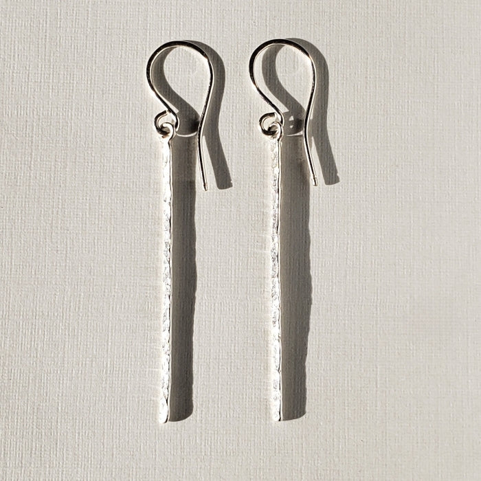 Long silver bar earrings with hammered texture hung on sterling ear wires 